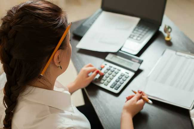 Woman using a calculator at her desk