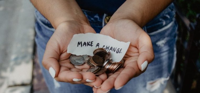 Hands holding coins with a note that says Make a Change