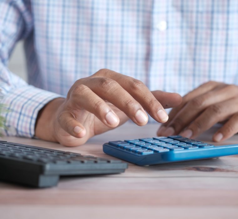 man's hands on blue calculator