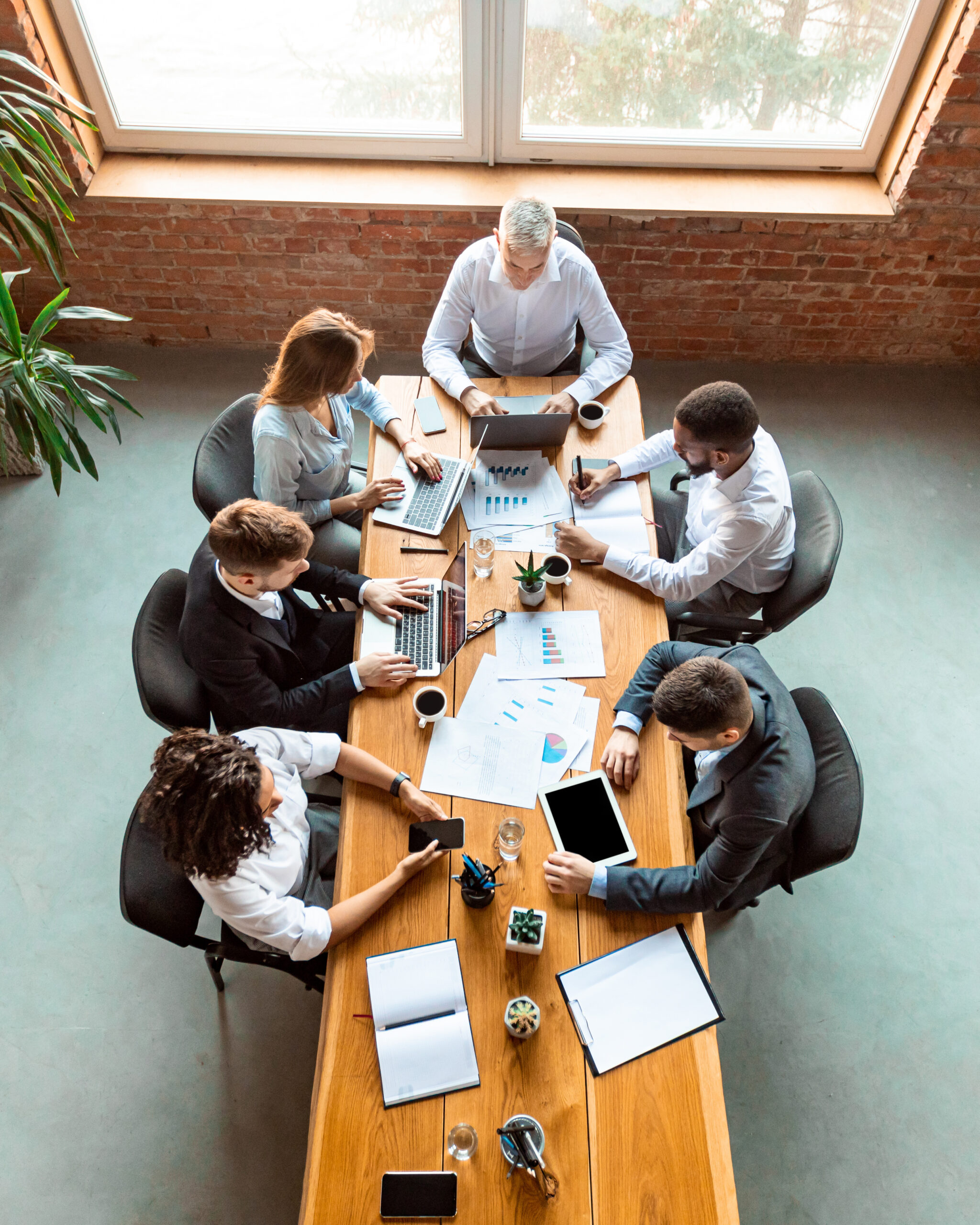 Diverse Coworkers Working Using Computers Sitting At Desk In Office